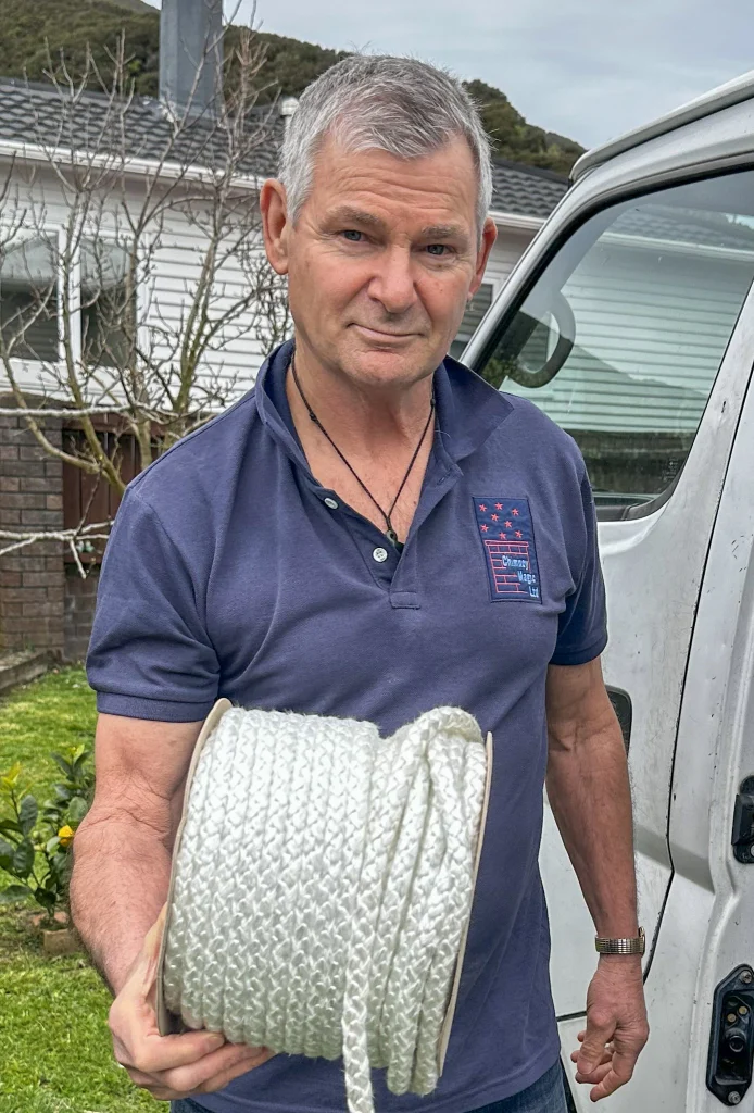 Alan from Chimney Magic holds a coil of door rope to repair wood burners